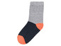 Eine graue und dunkelblaue Socke mit einem orangefarbenen Akzent.