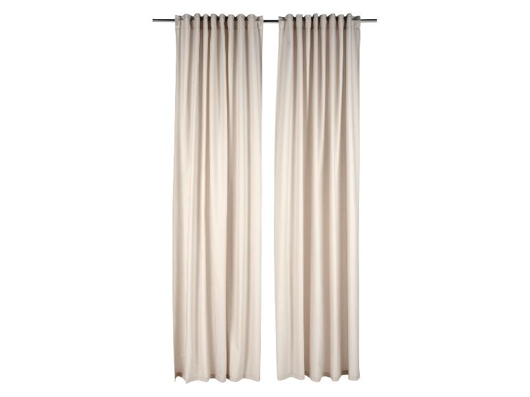 Zwei beige Vorhänge hängen an einer Gardinenstange