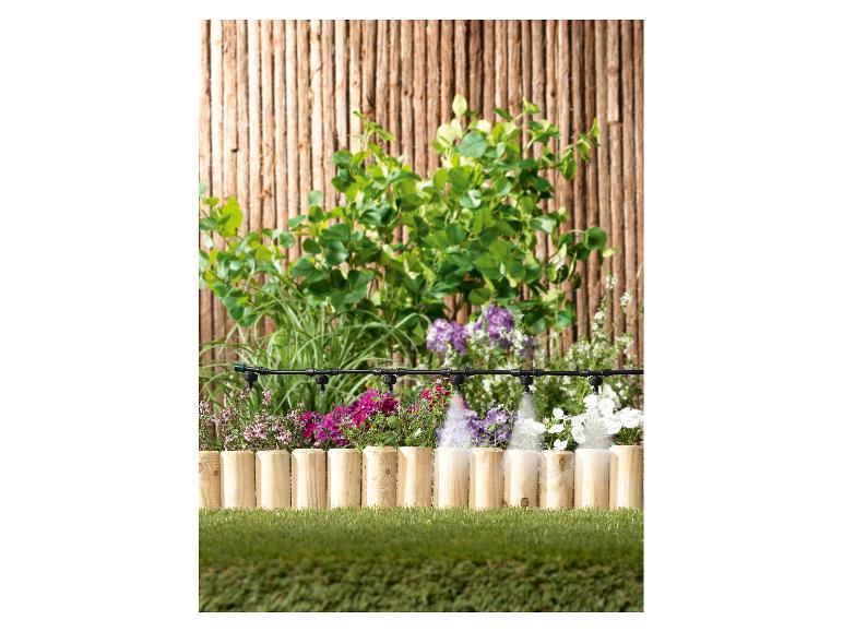 Gartenbewässerungssystem mit Sprinklern, die bunte Blumen und Pflanzen bewässern.