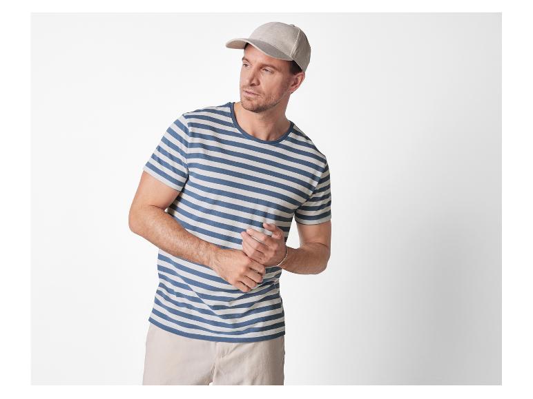 Ein Mann trägt ein gestreiftes T-Shirt und eine Baseballkappe.