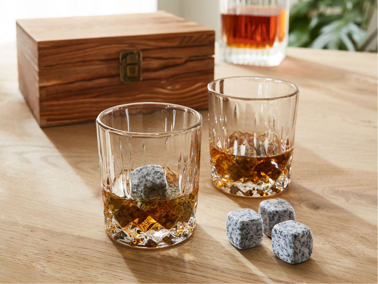 Zwei Gläser Whisky mit Whiskey Steinen in einer Holzkiste.