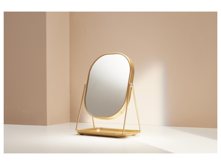 Ein goldener Make-up-Spiegel mit Tablett.