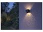 Außenwandleuchte mit Up- und Downlight in einem nächtlichen Garten.