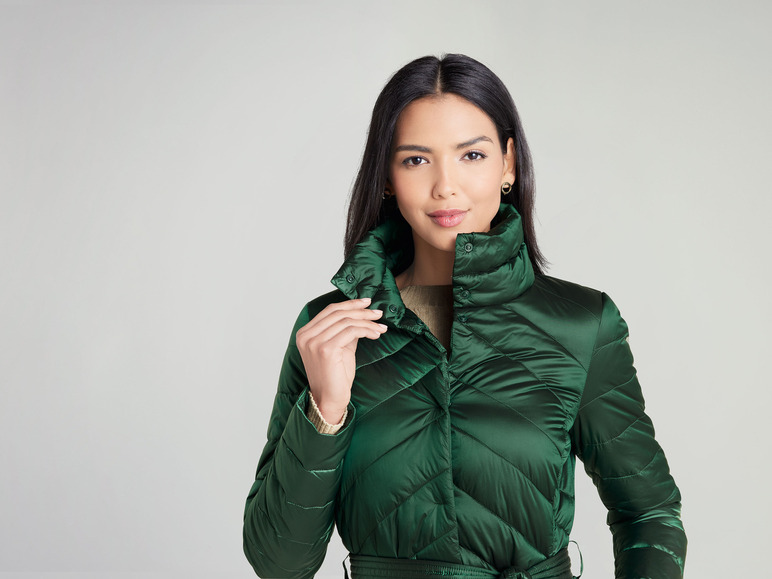 Eine Frau trägt eine grüne gesteppte Jacke