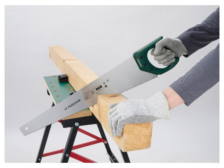 Handsäge schneidet ein Holzbrett auf einem Sägebock, mit Schutzhandschuhen.