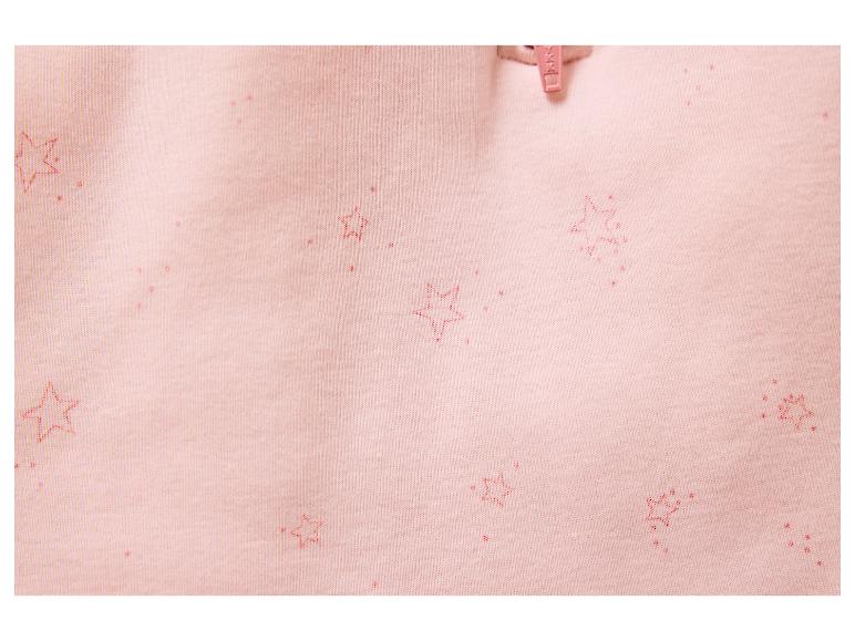 Nahaufnahme von rosa Stoff mit roten Sternmustern und einem kleinen rosa Reißverschlusszipper