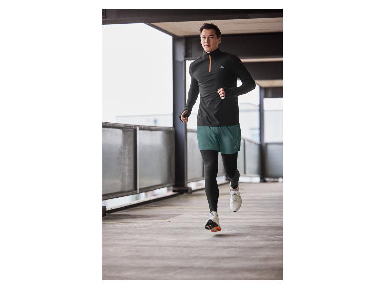 Mann in schwarzer Sportbekleidung und grünen Shorts läuft in einer Tiefgarage.