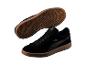 Schwarze Wildleder-Sneaker mit braunen Gummisohlen, ein Schuh aufrecht, einer umgedreht.