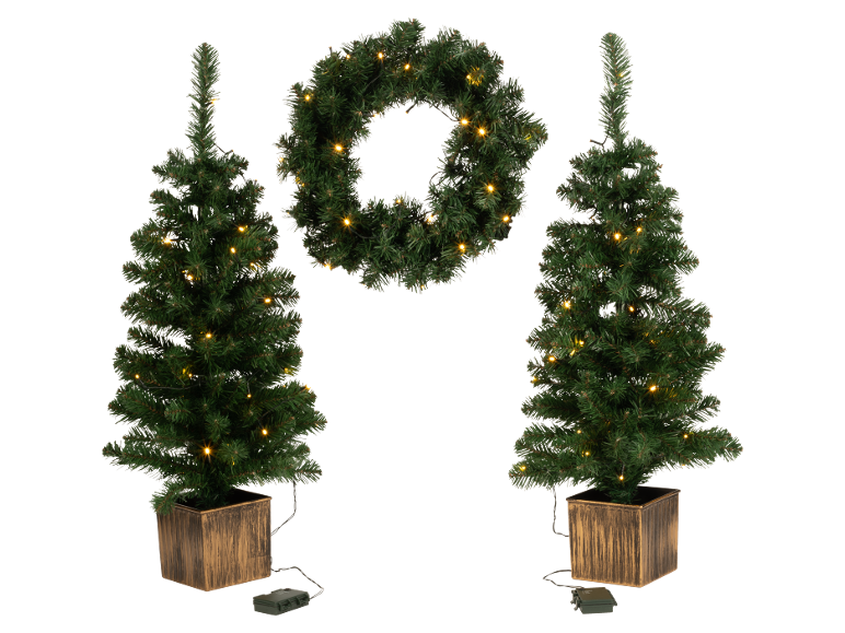 Zwei vorbeleuchtete künstliche Weihnachtsbäume in quadratischen Pflanzgefäßen und ein passender vorbeleuchteter Kranz.