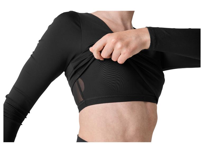 Frau passt ein schwarzes langärmeliges Thermoshirt an, Oberkörper sichtbar.