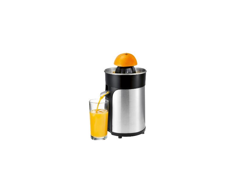 Entsafter mit Orange und einem Glas Orangensaft