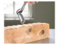 Ein Universalschlüssel schraubt eine Schraube in einen Holzbalken.