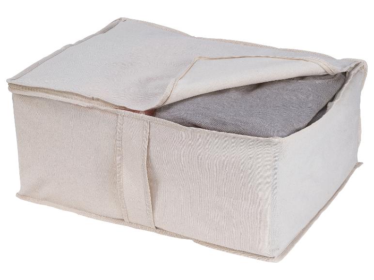 Beige Stoffaufbewahrungsbeutel mit gefalteten Kleidungsstücken.