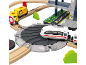 Spielzeugeisenbahn-Set mit gelben U-Bahn-Wagen, weißem Zug und mehrstöckigem Bahnhof.