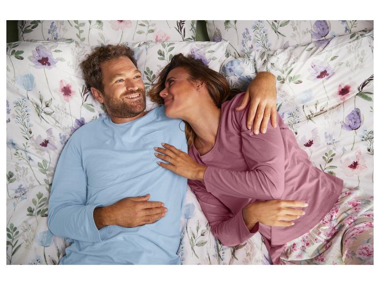 Ein Paar im Bett mit Blumenbettwäsche.