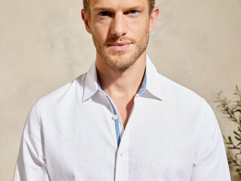 Mann in einem weißen Leinenhemd mit blauem Kragenfutter.