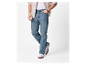 Mann in hellblauen Jeans, weißem T-Shirt und beigem Hemd.