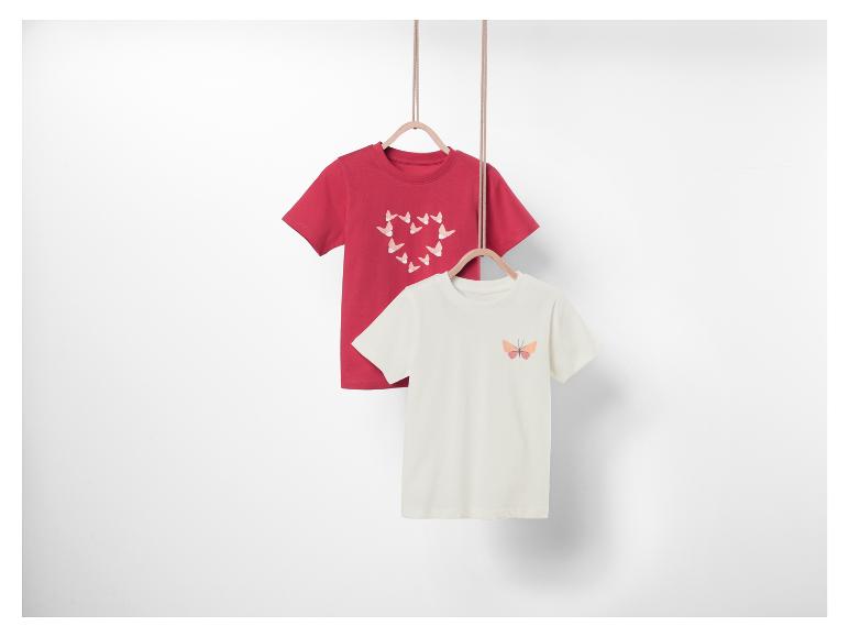 Zwei T-Shirts mit Schmetterlingsmotiv, eines rot mit Schmetterlingen in Herzform und eines weiß mit einem einzelnen Schmetterling.