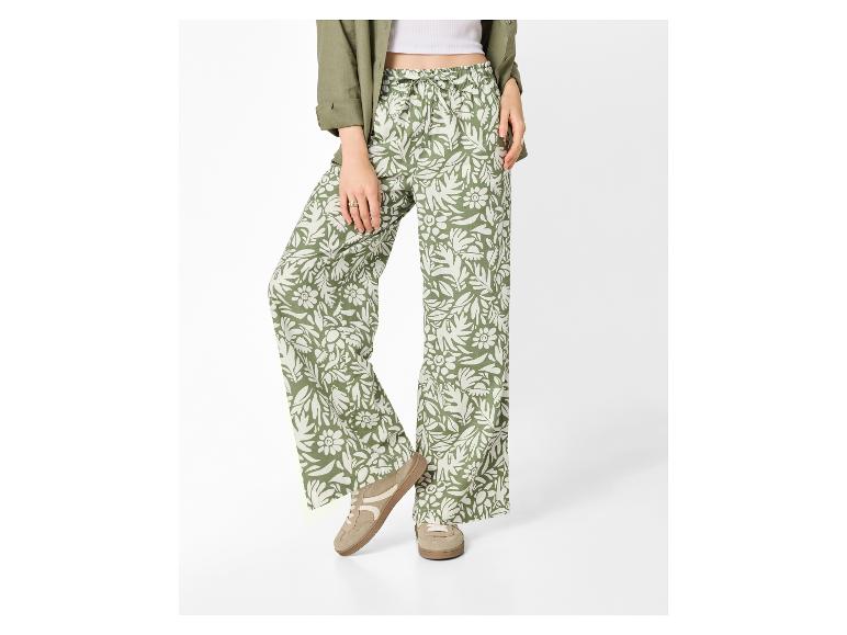 Damenhose mit Blumenmuster, grünes Hemd und weiße Sneaker.