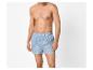Mann ohne Oberteil, bekleidet mit blau gestreiften Boxershorts.