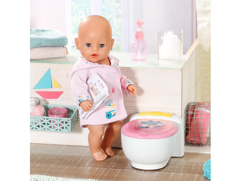 Puppe im Bademantel mit Töpfchen, Handtüchern und Badaccessoires.