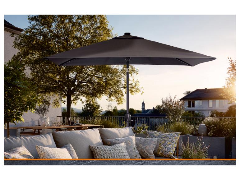 Grauer Gartenschirm auf einer Terrasse mit Sofa und Kissen.