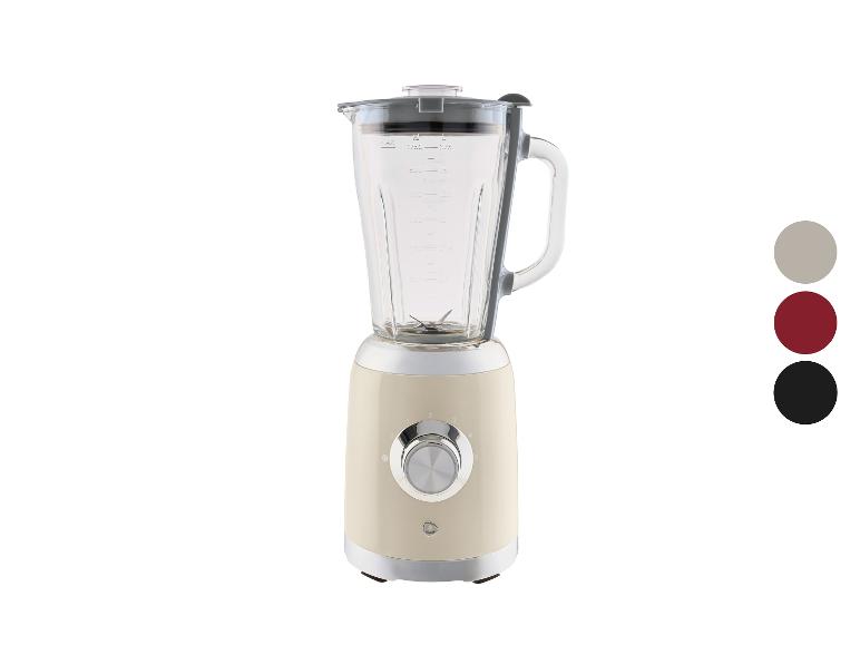 Cremefarbener Mixer mit Messbecher und Geschwindigkeitsregelung, in drei Farben erhältlich.