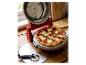 Eine frisch gebackene Peperoni-Pizza in einem roten elektrischen Pizzaofen, mit einem Pizzaschneider daneben.