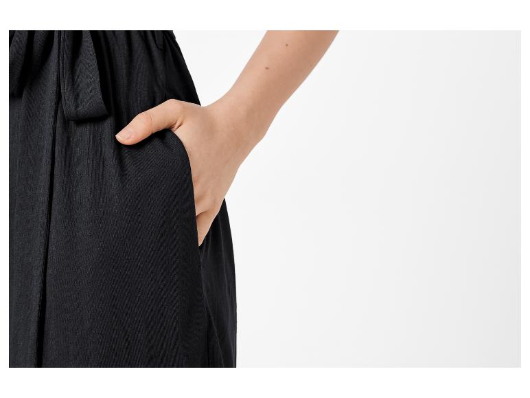 Schwarze Hose mit einer Hand in der Tasche.