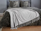 Eine graue gestrickte Decke mit Fransen der Marke Michaelsky.