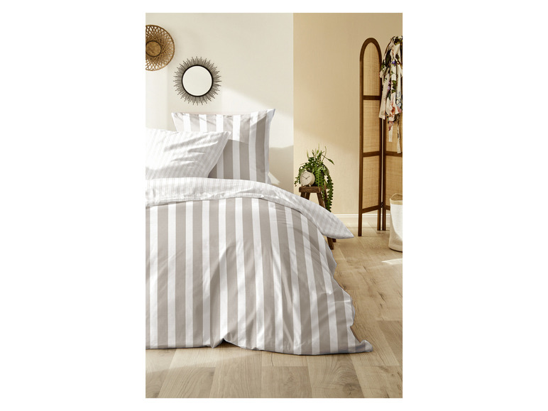 Beige gestreiftes Bettbezug-Set auf einem Bett.