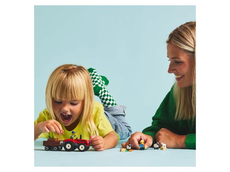 Kind und Erwachsener spielen mit LEGO Duplo Bauernhofspielzeug, inklusive Traktor und Tieren.