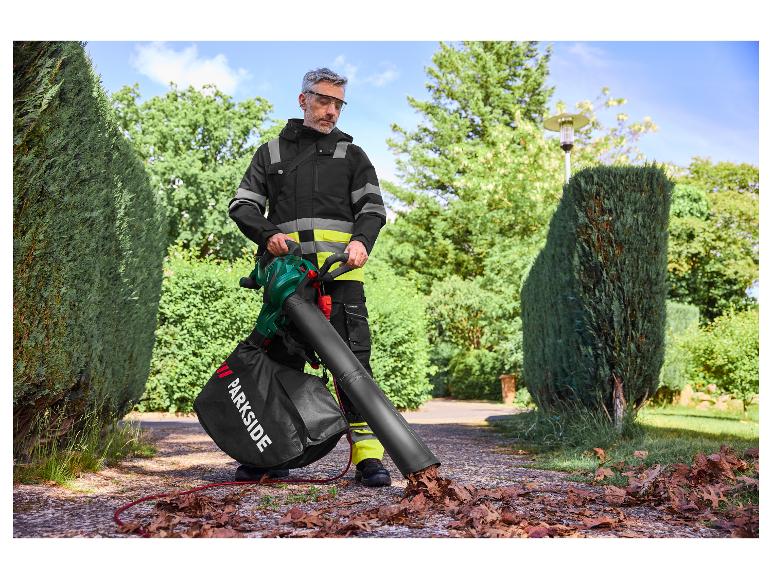 Ein Mann benutzt einen Parkside Laubbläser, um Blätter auf einer Auffahrt zusammenzukehren.