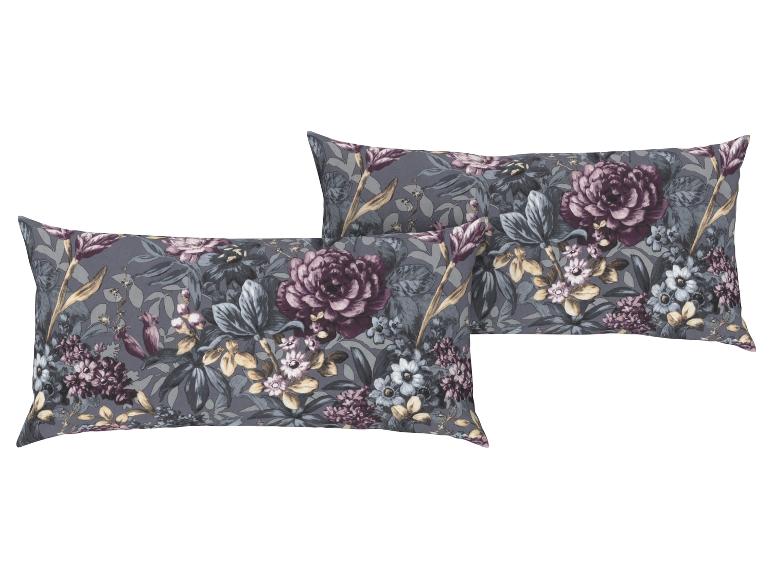 Zwei dekorative Kissen mit Blumenmuster.