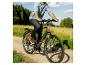 Mann fährt E-Bike auf einem Feldweg durch ein Feld.