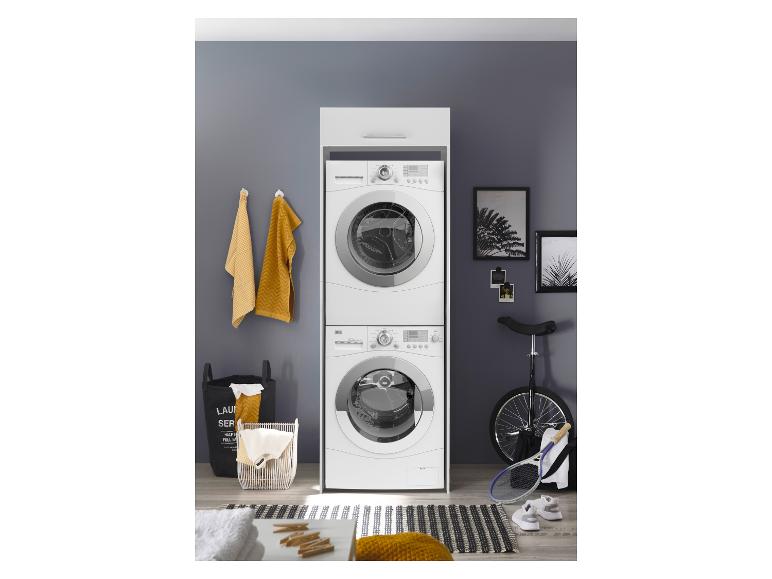 Gestapelte Waschmaschine und Trockner in einem Waschraum mit Körben und Sportgeräten.