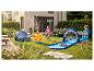 Kinder spielen mit Seestern-Sprinkler und Hai-Wasserrutsche im Garten.