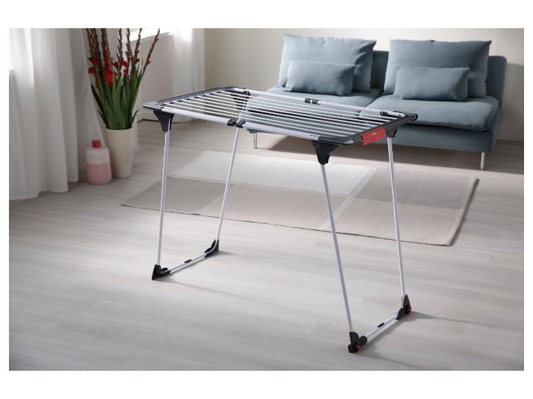Klappbarer Wäscheständer in einem modernen Wohnzimmer mit Sofa und Dekoration.