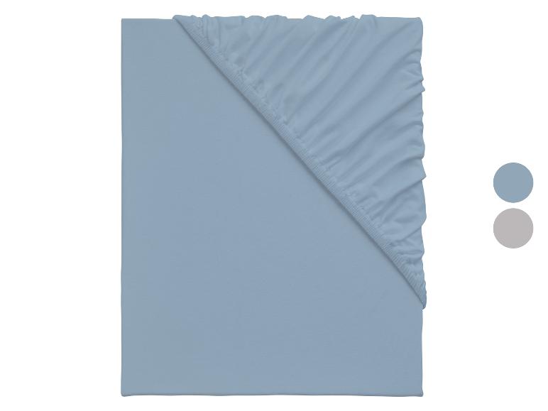 Hellblaues Spannbettlaken mit blauen und grauen Farbmustern.