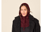 Frau in schwarzem Mantel und bordeauxroter Strickkapuze.