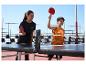 Frau und Kind spielen Tischtennis mit roten Schlägern, Crivit Tisch und Netz.