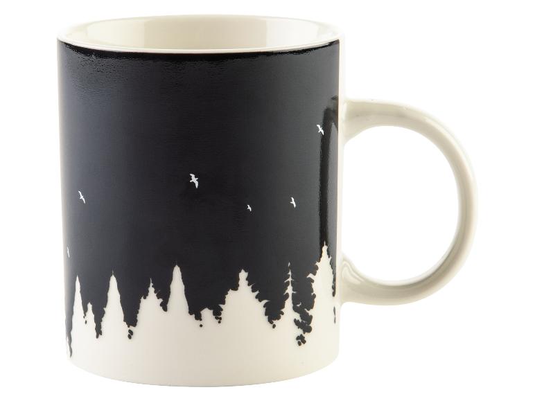 Eine weiße Tasse mit einem schwarzen Bild von einem Wald und Vögeln.
