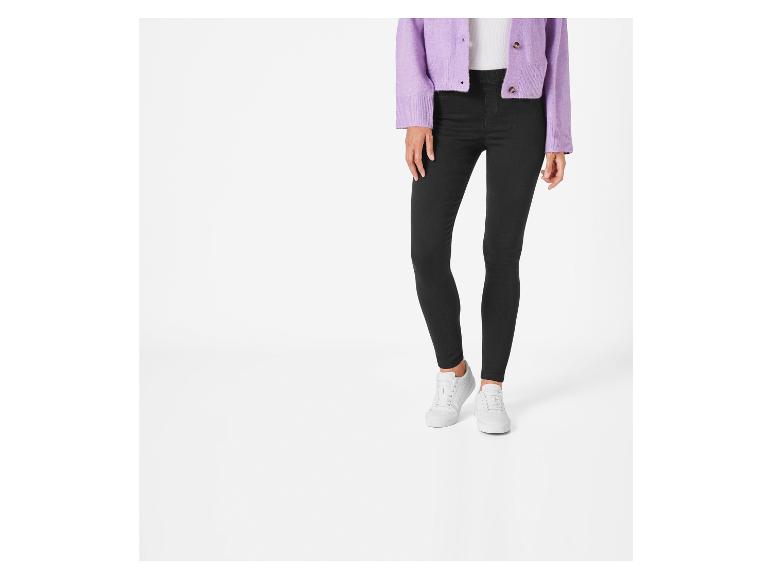 Schwarze Skinny Jeans, weiße Sneaker und ein lilafarbener Pullover.