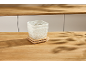 Zwei weiße Drahtkörbe mit Holzdeckeln auf einem Holztisch.