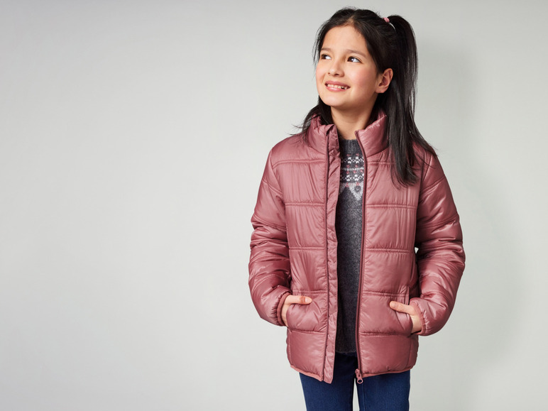 Ein Mädchen trägt eine rosafarbene Winterjacke.