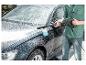 Mann wäscht Auto mit Hochdruckreiniger und Schaumdüse.