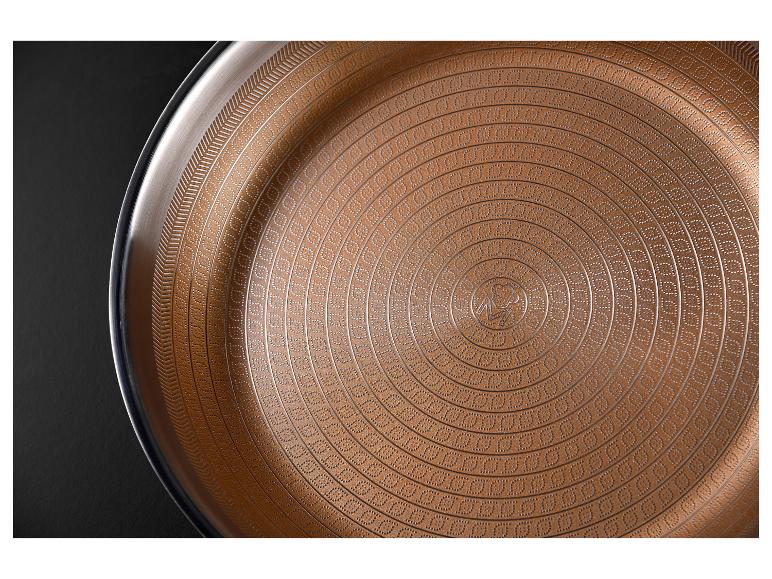 Nahaufnahme einer runden kupferfarbenen Pfanne mit strukturiertem, konzentrischem Muster.