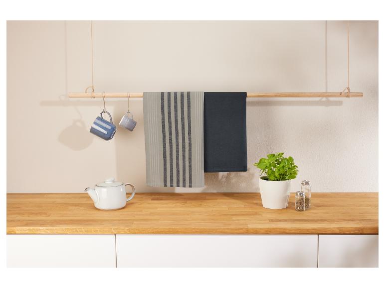 Geschirrtücher, Tassen und Teekanne in einer modernen Küche.