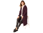 Frau in langem pflaumenfarbenem Cardigan, weißem Hemd und schwarzer Kunstleder-Leggings, auf einem Hocker sitzend.