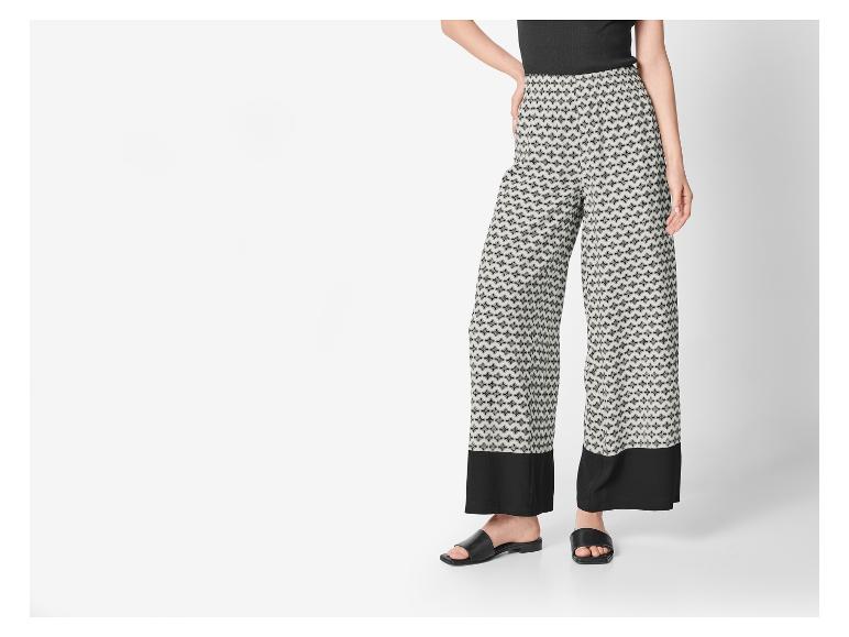 Palazzohose mit geometrischem Muster und flachen Sandalen.